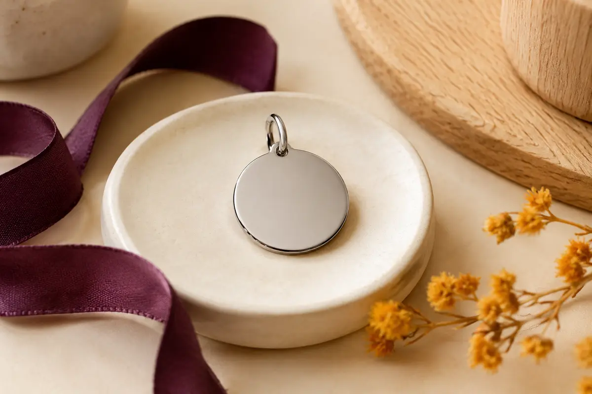 Médaille personnalisable pour animal en acier brillant présentée sur un fond crème avec un ruban prune