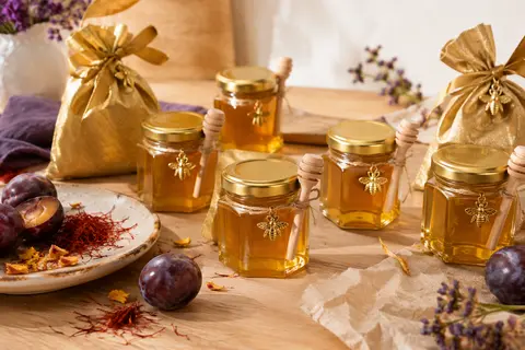 Mini pots hexagonaux en verre avec accessoires dorés et cuillères en bois, présentés sur une table claire