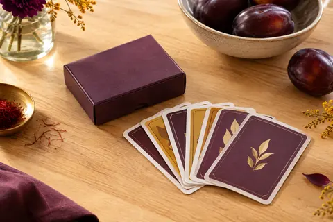Boîte compacte et cartes d’un jeu de bluff posées sur une table en bois clair