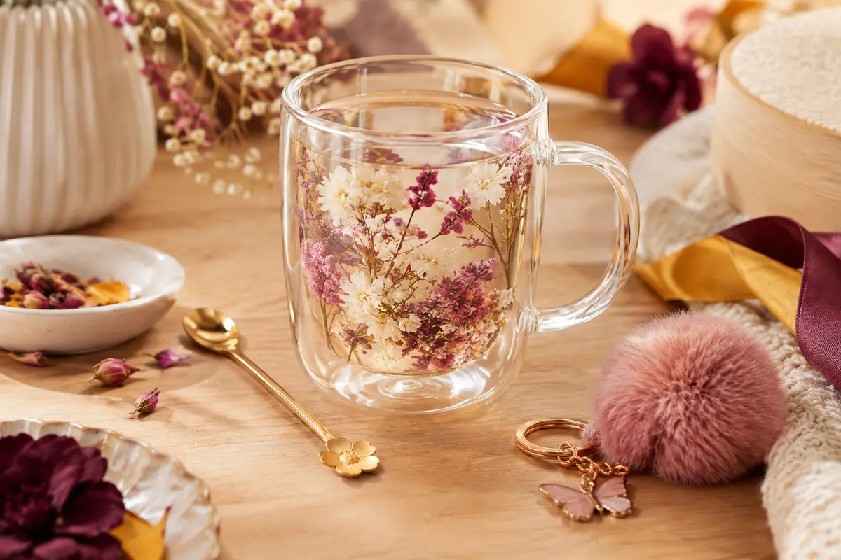 Mug transparent à double paroi orné de fleurs séchées roses et blanches, avec cuillère et porte-clés assortis.