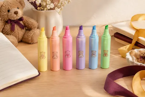 Six mini surligneurs pastel Legami à pointe biseautée présentés près d’un carnet sur un bureau clair.