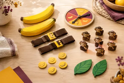 Jeu de société It’s Bananas présenté avec ses queues, ceintures, spinner, singes et jetons banane
