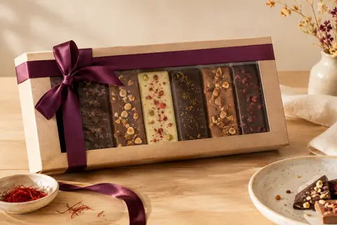 Grande tablette cadeau réunissant six chocolats Milka sous une enveloppe sobre, sur un fond crème.