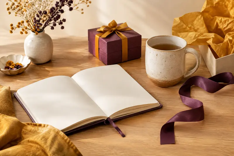 Composition de cadeaux et de matières tactiles sur fond crème, éclairée par une lumière naturelle douce.